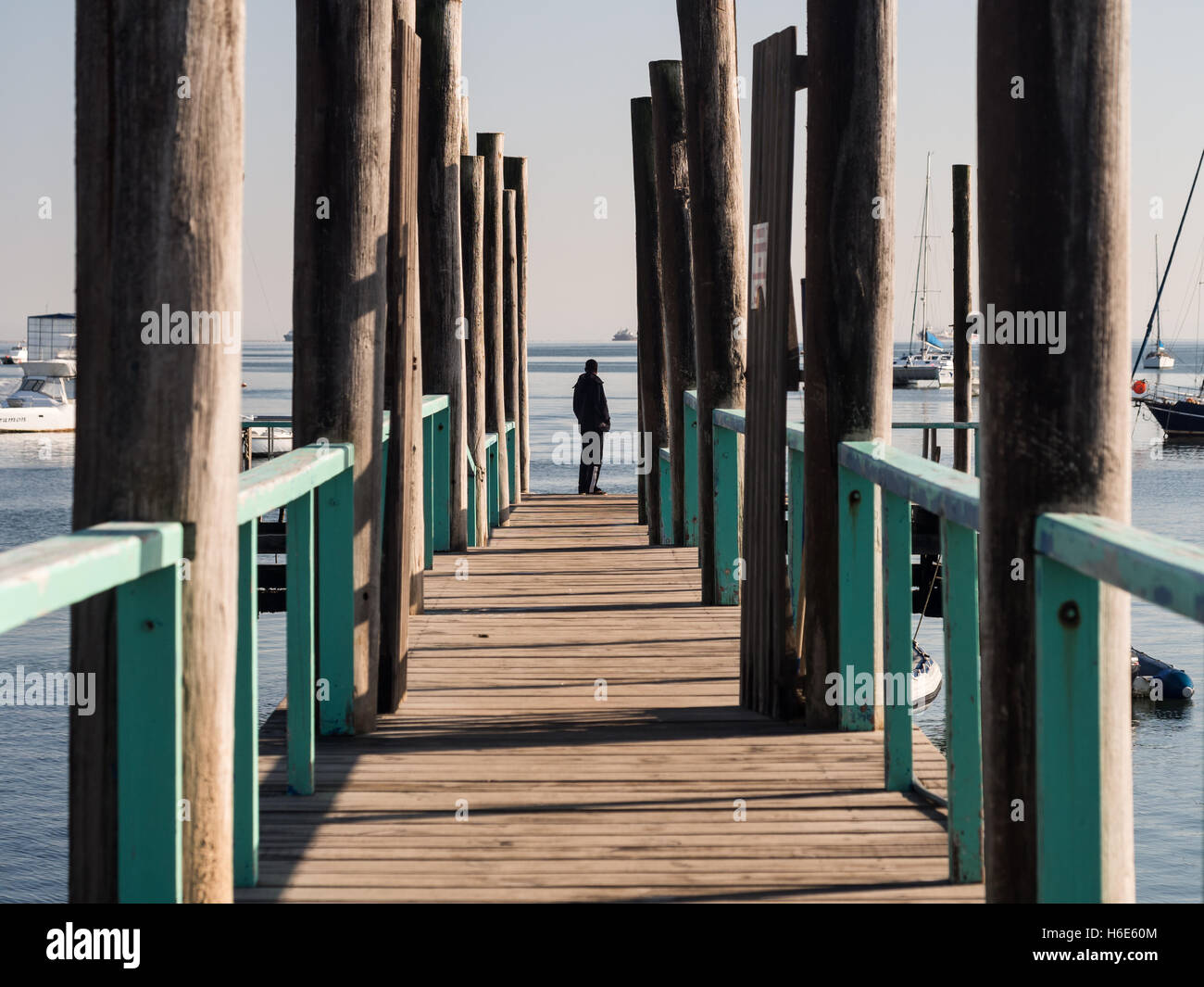 Person standing at the end of a bridge in the port in Walvis Bay, Namibia. Stock Photo