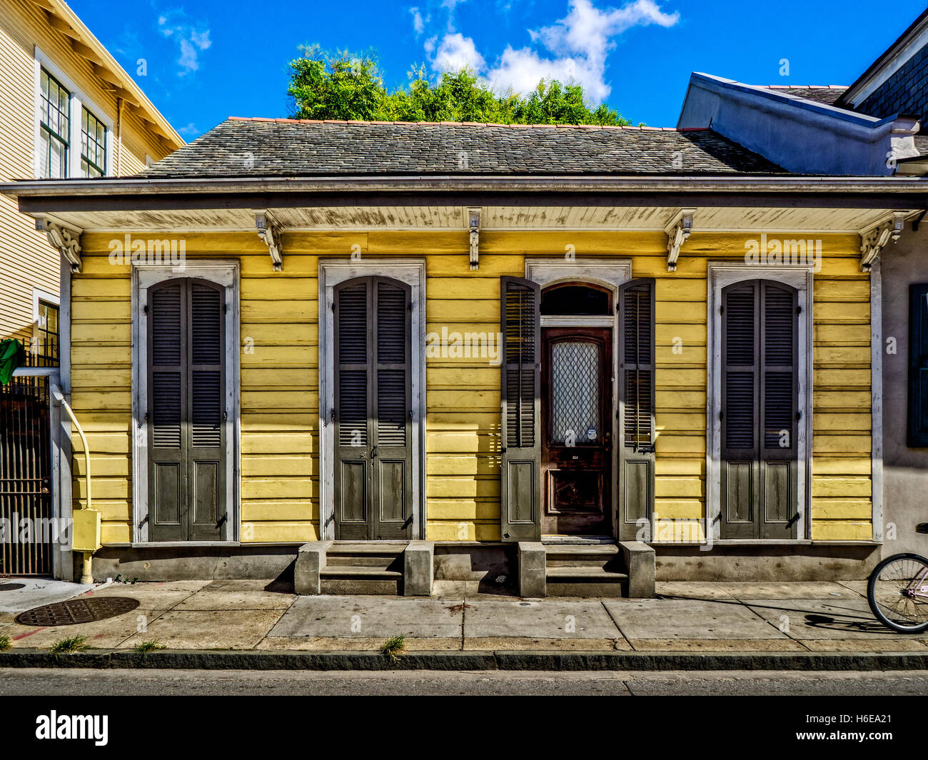 Yellow Shotgun House with Shutters and Door in the French Quarter, New Orleans. Stock Photo