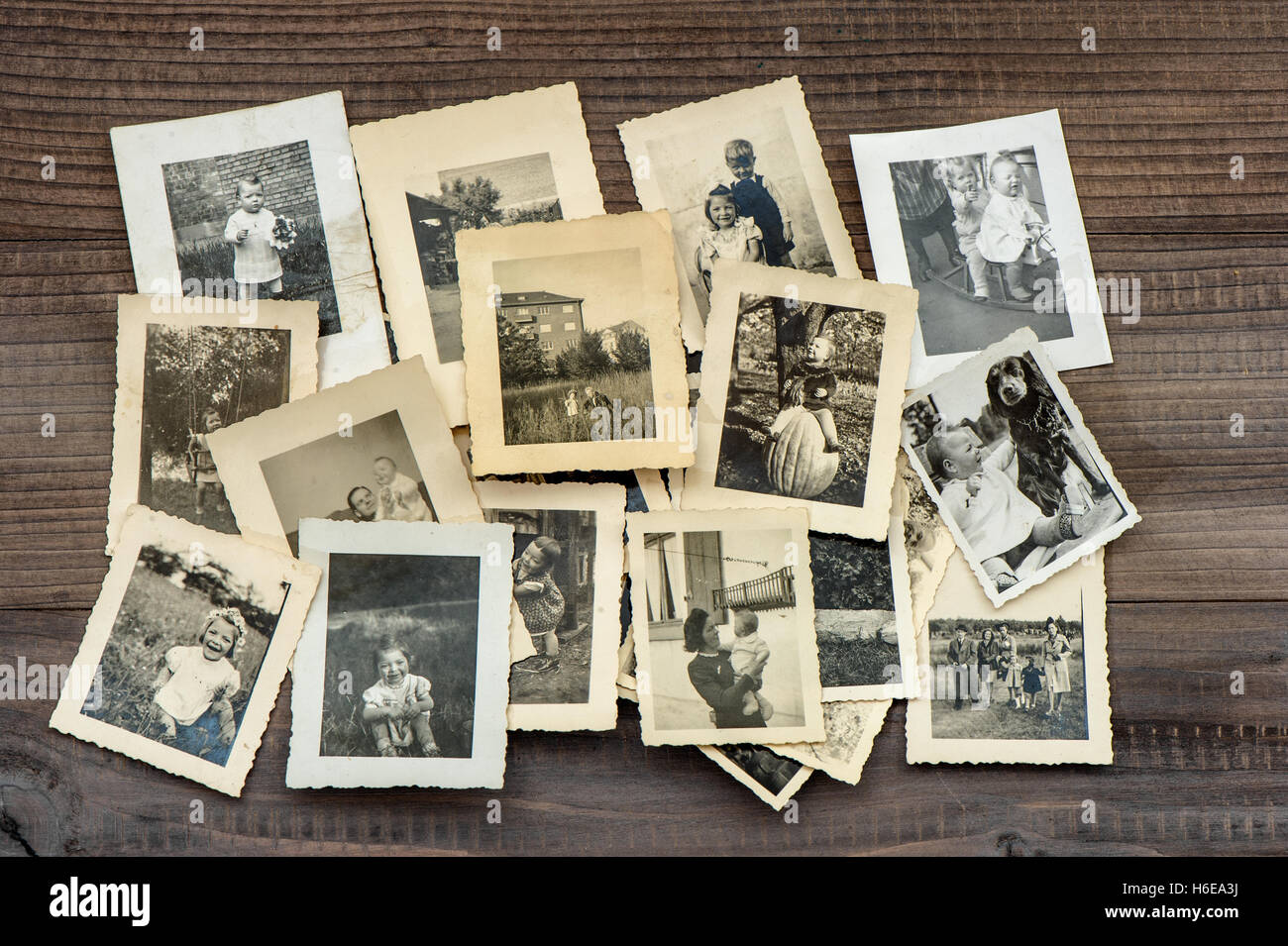 Vintage family photos on wooden table. Old pictures used paper Stock Photo