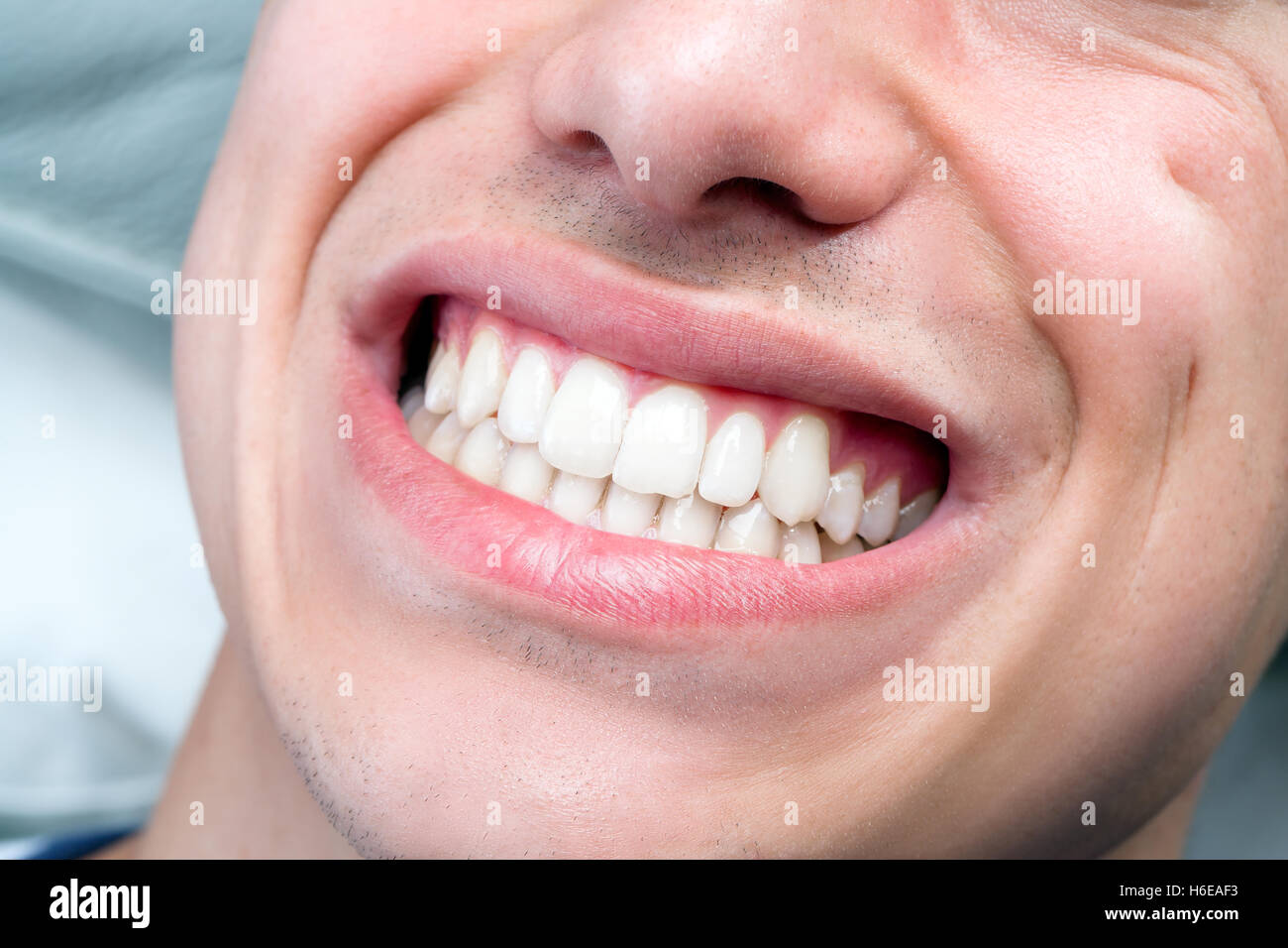Macro close up of human male mouth showing perfect white teeth. Stock Photo