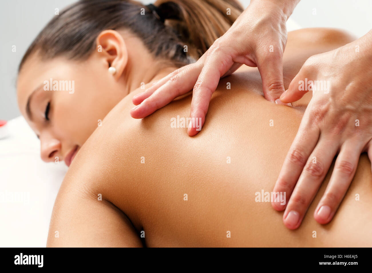 Close up of Therapist doing curative healing massage with thumbs on female back. Stock Photo