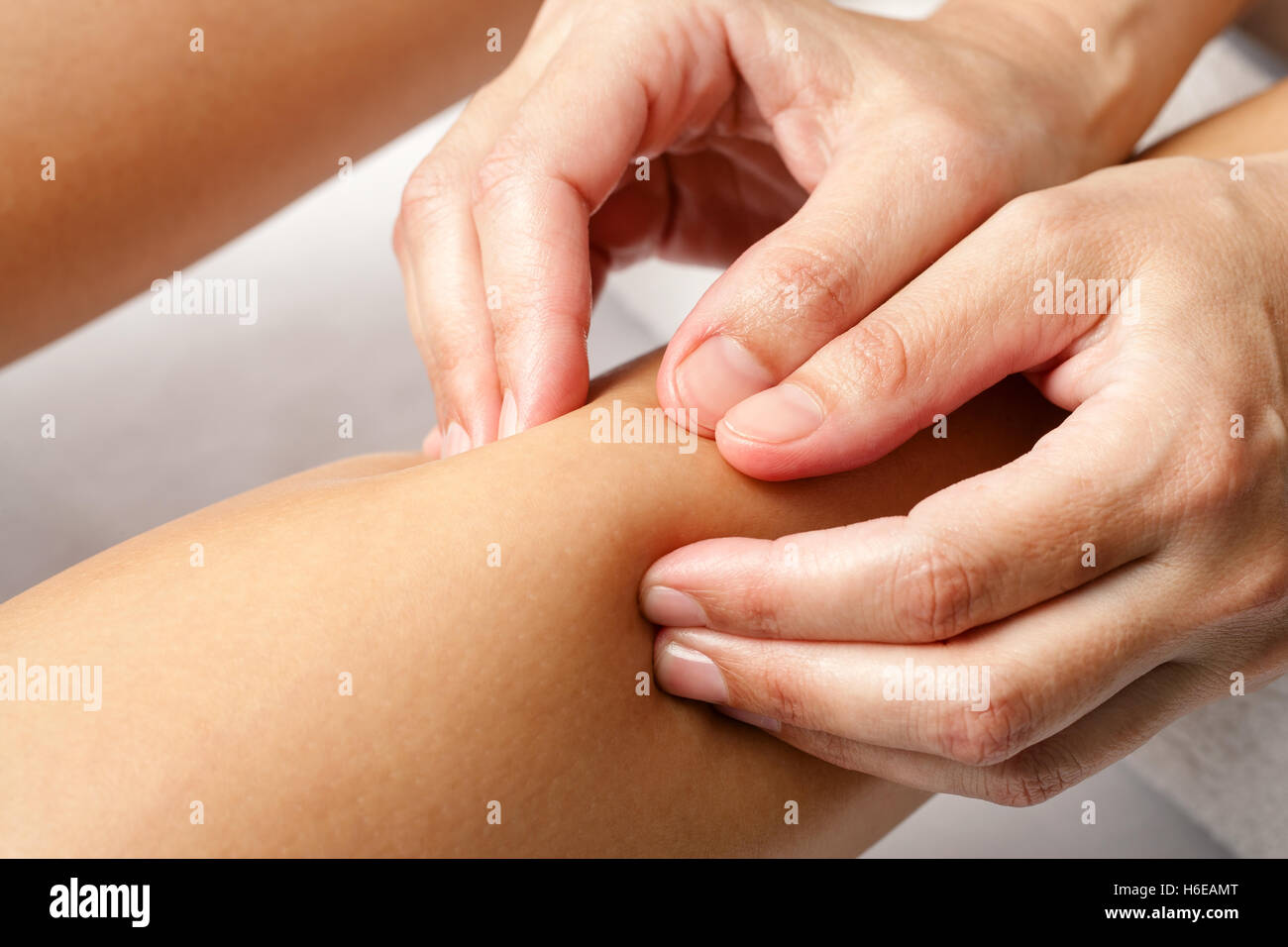 Macro close up of hands doing rehabilitation massage on female calf muscle. Stock Photo