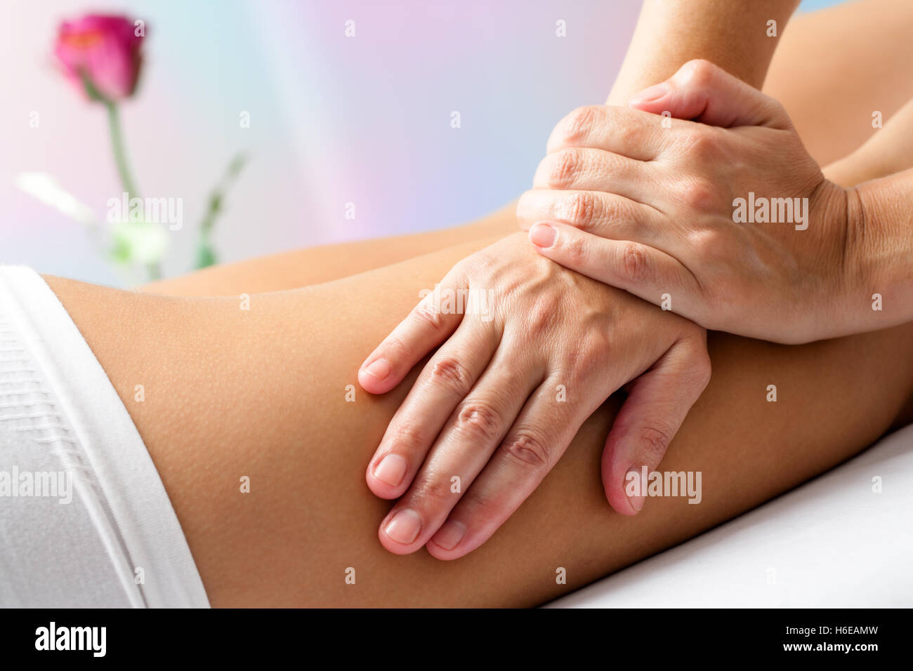 Close up Detail of Hands massaging female hamstrings. Therapist doing manipulative treatment on upper back leg. Stock Photo