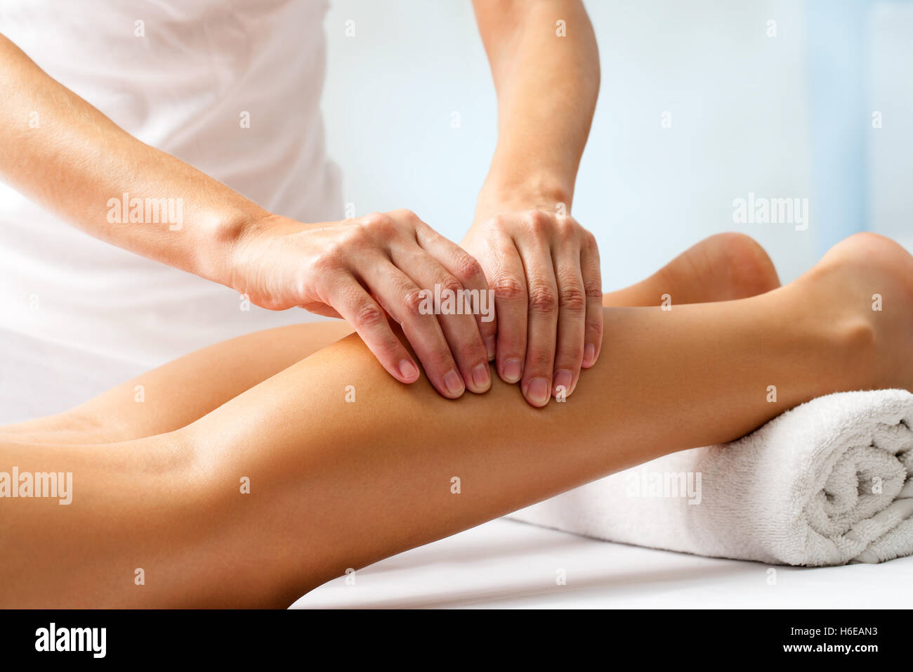 Detail of hands massaging human calf muscle.Therapist applying pressure on female leg. Stock Photo