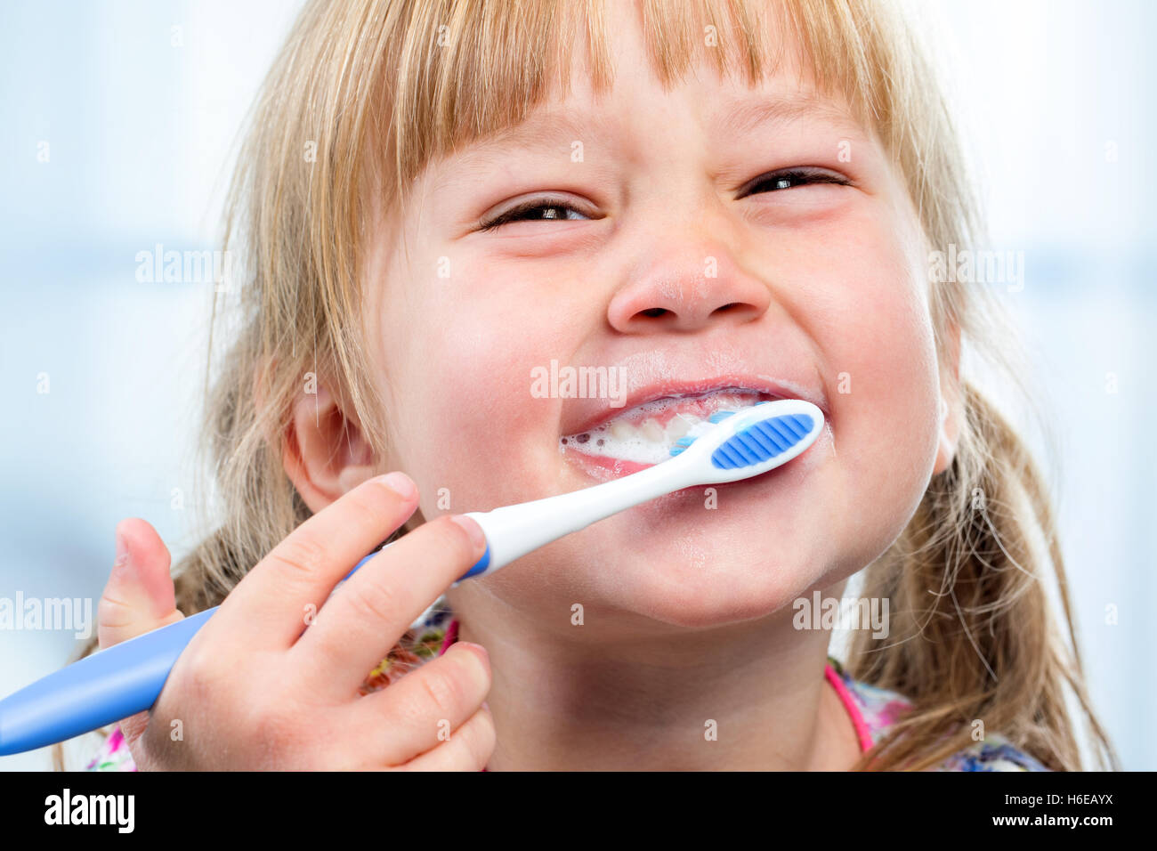Macro close up of little girl having fun brushing teeth. Stock Photo
