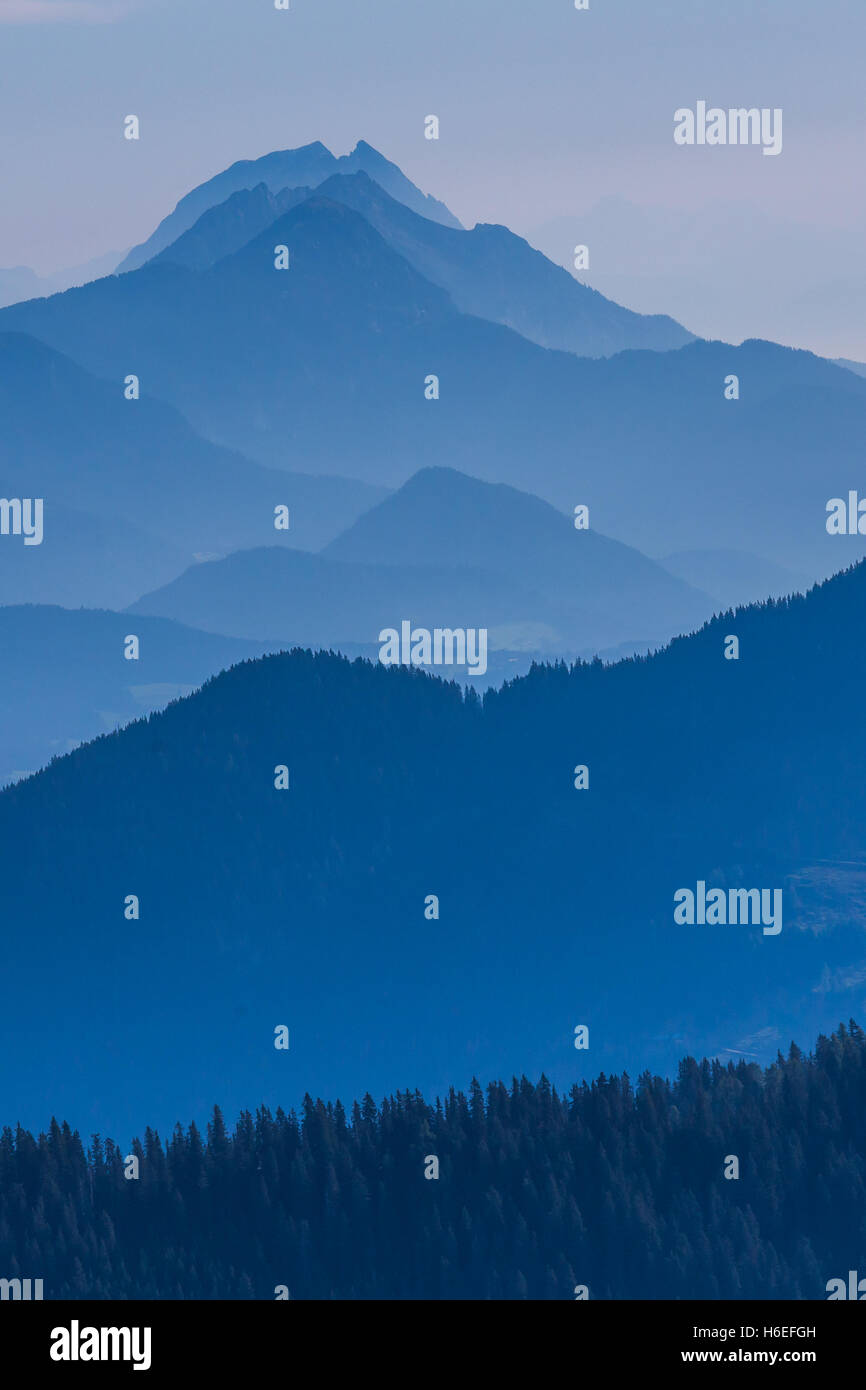 During a blue dawn in the Austrian Alps, only the silhouettes of the mountains are visible. Stock Photo