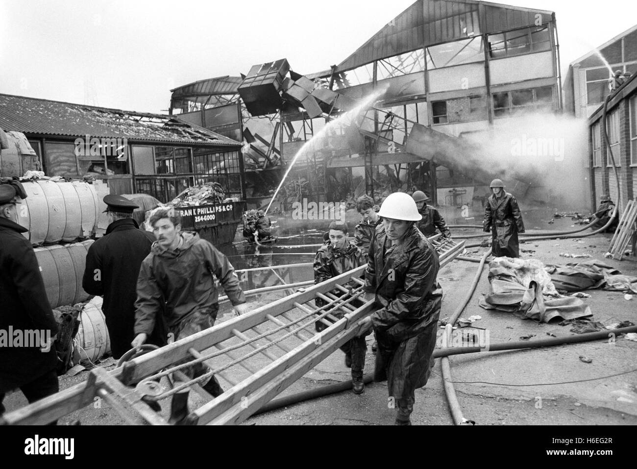 soldiers rushing into action with a ladder unloaded from a 'Green Goddess' fire engine as army firefighters battled a blaze at C and N Rags Ltd in Stratford, London. Stock Photo