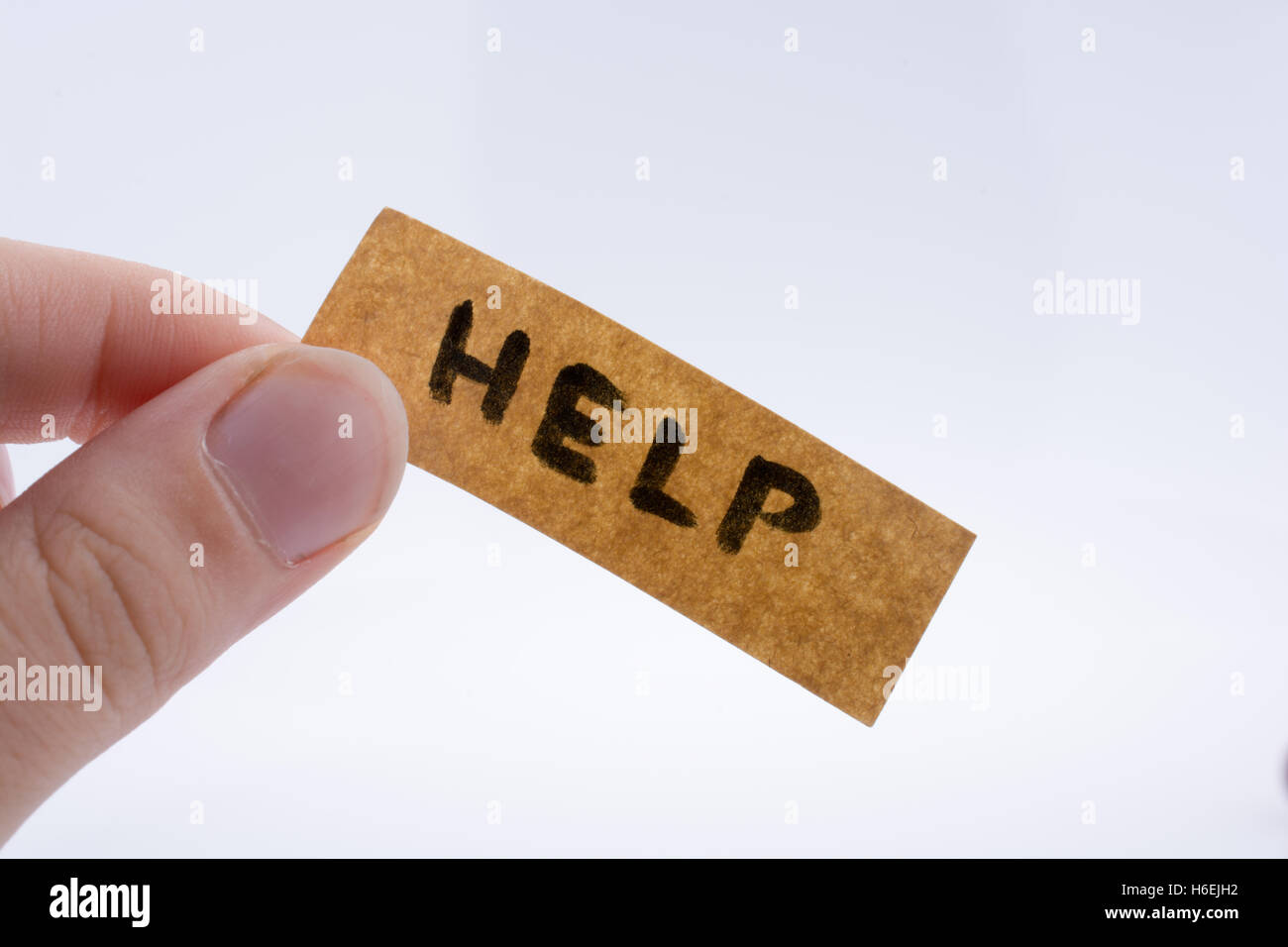 Help word on a piece paper in hand Stock Photo - Alamy