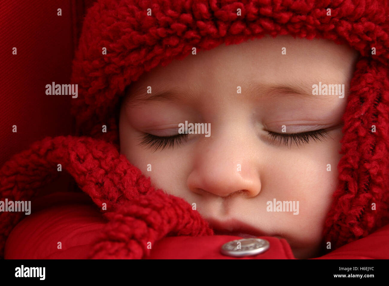 Closeup of baby girl sleeping in stroller outside, in a cold day Stock