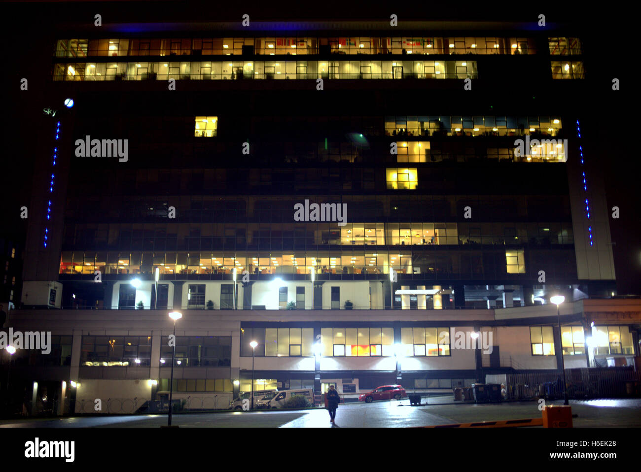 individual man walking away from illuminated  skypark  finnieston glasgow office tower block at night Stock Photo