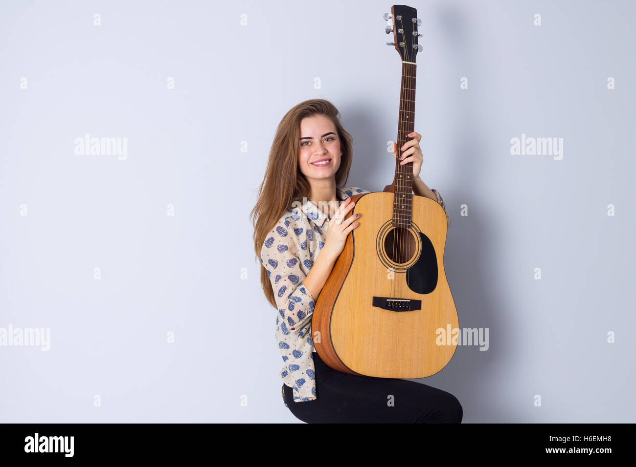Young woman holding a guitar Stock Photo - Alamy