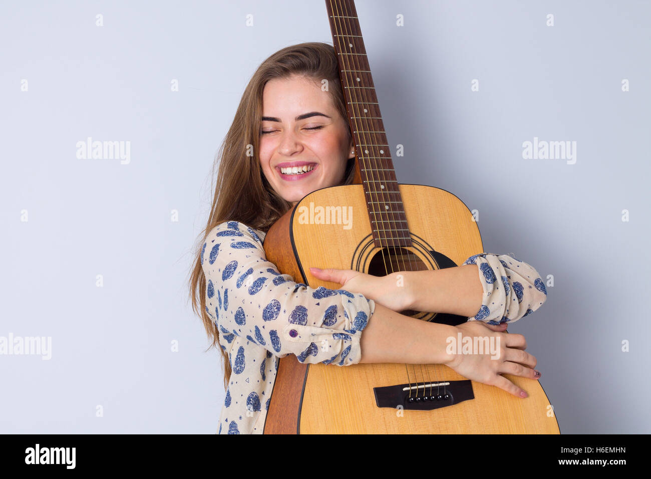 Young woman holding a guitar Stock Photo - Alamy