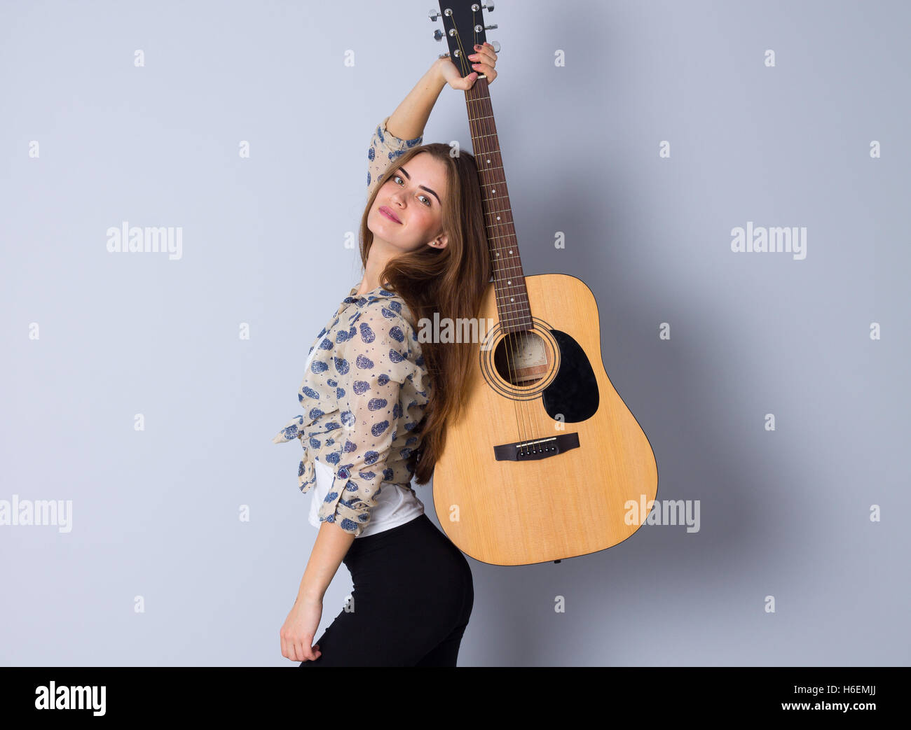 Young woman holding a guitar Stock Photo - Alamy