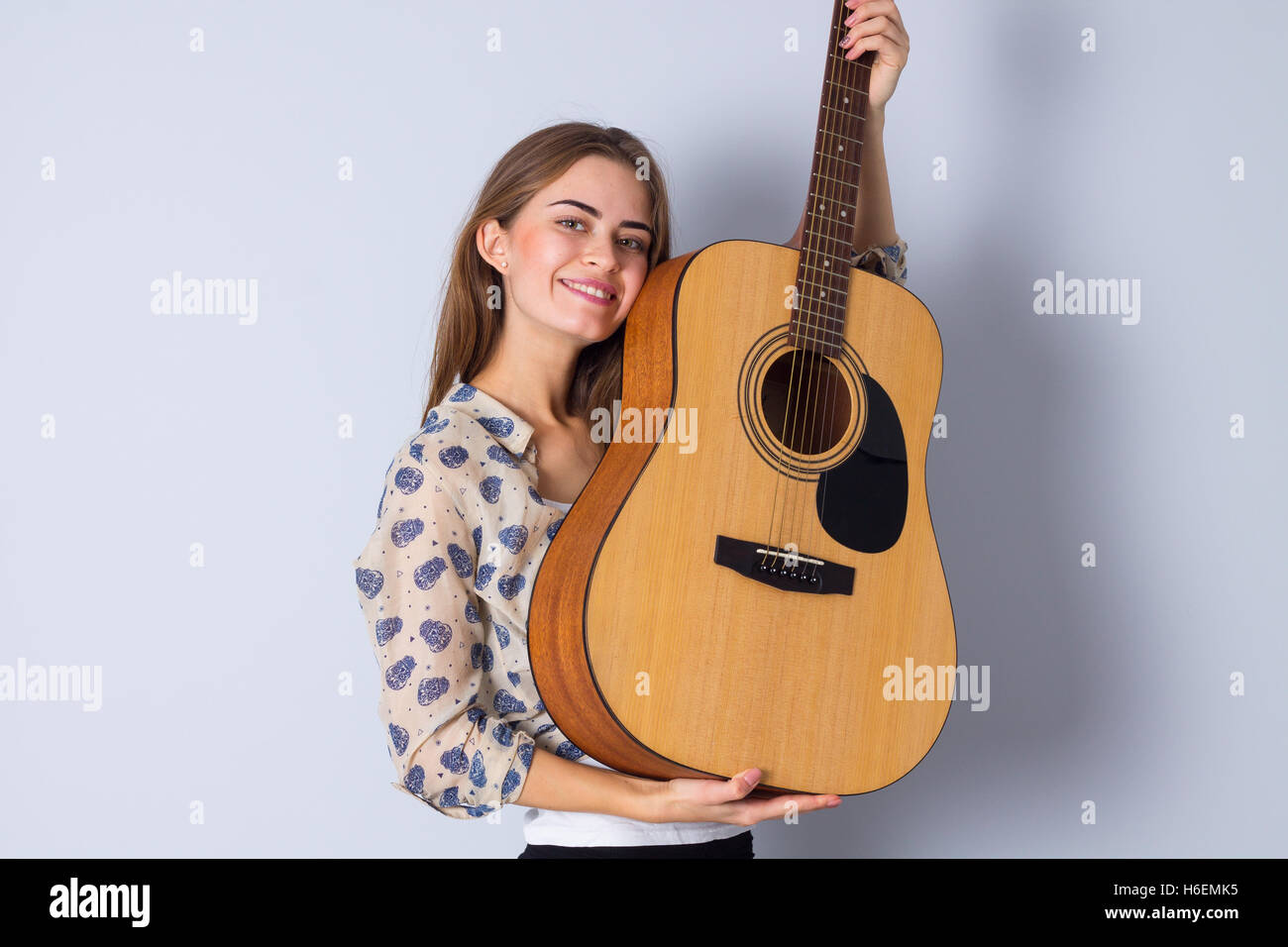 Young woman holding a guitar Stock Photo - Alamy
