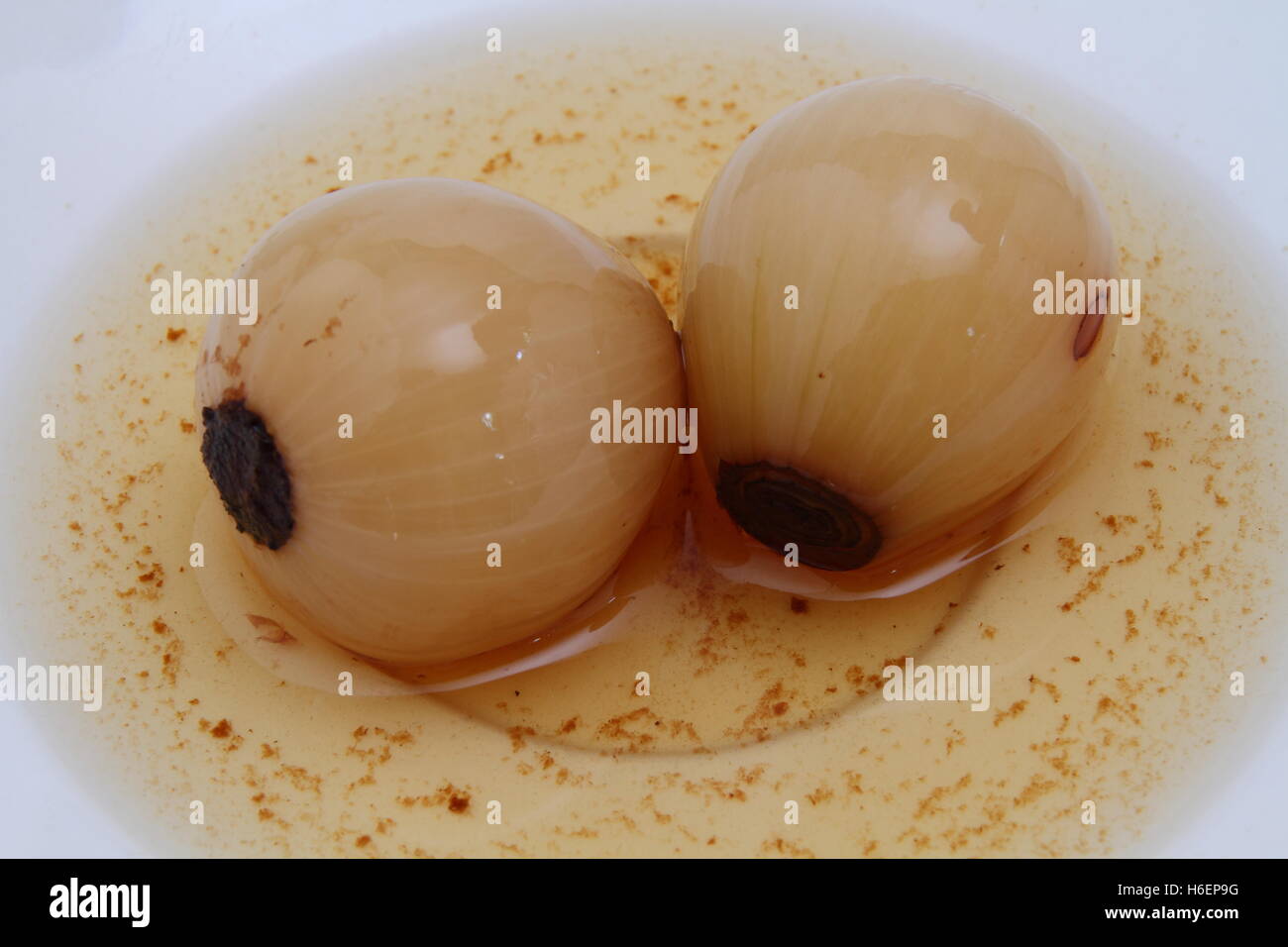 Pickled onions in vinegar isolated in a small side plate image with