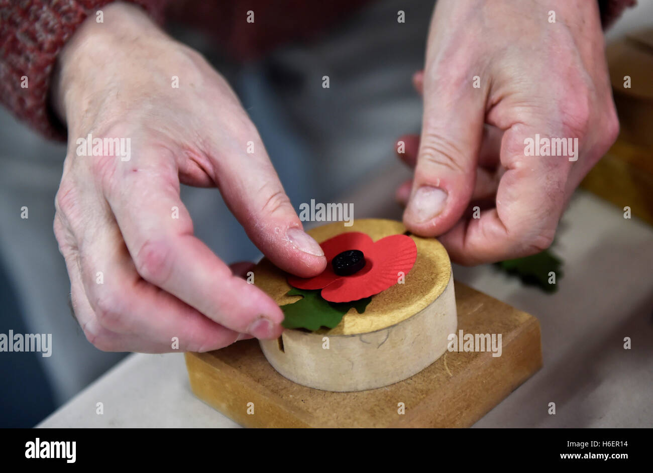 A worker puts together the components of a standard poppy at a Poppy Factory in Richmond, London, as the Royal British Legion mark the first day of their annual Poppy Appeal. Stock Photo