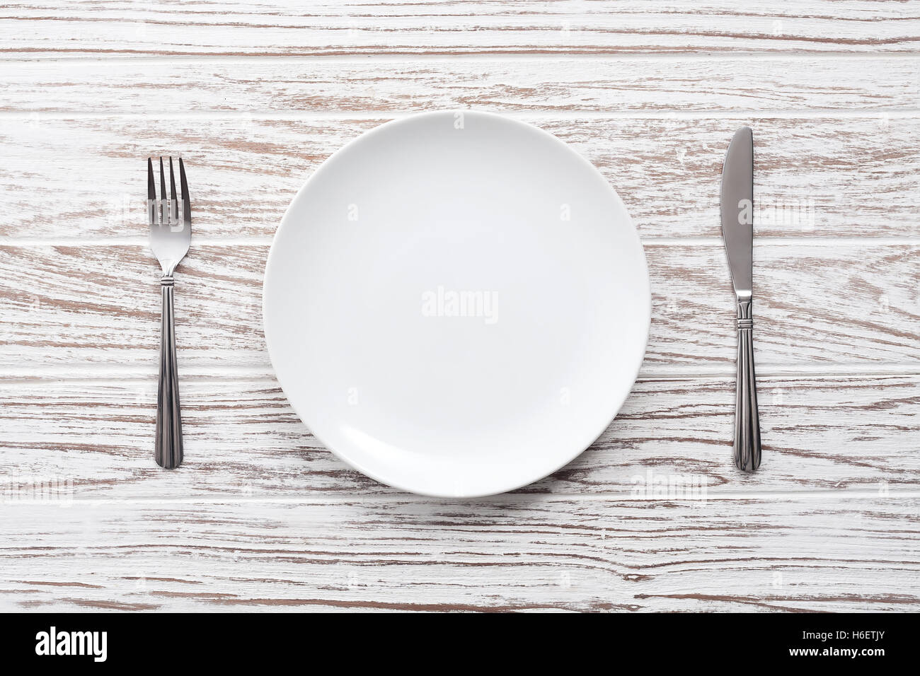 empty plate fork knife silverware white wooden table background still ...