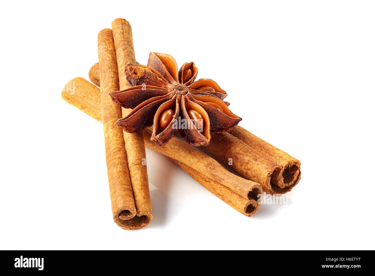 Three cinnamon sticks and star anise on white Stock Photo