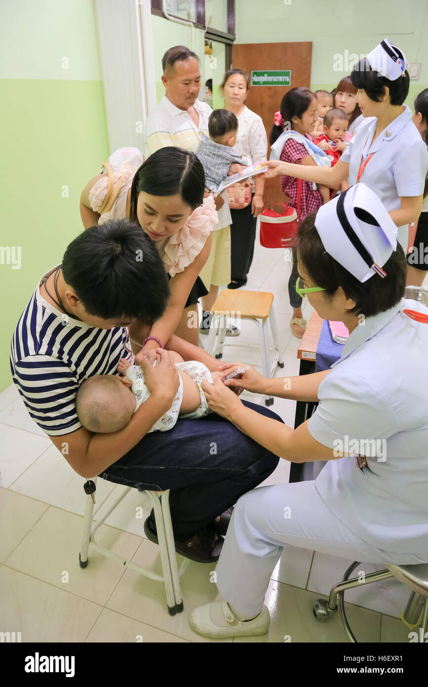 CHIANG MAI, Thailand - August 7, 2016: Mother and her Child receiving vaccine at out side of the thigh.Children vaccine in hospi Stock Photo