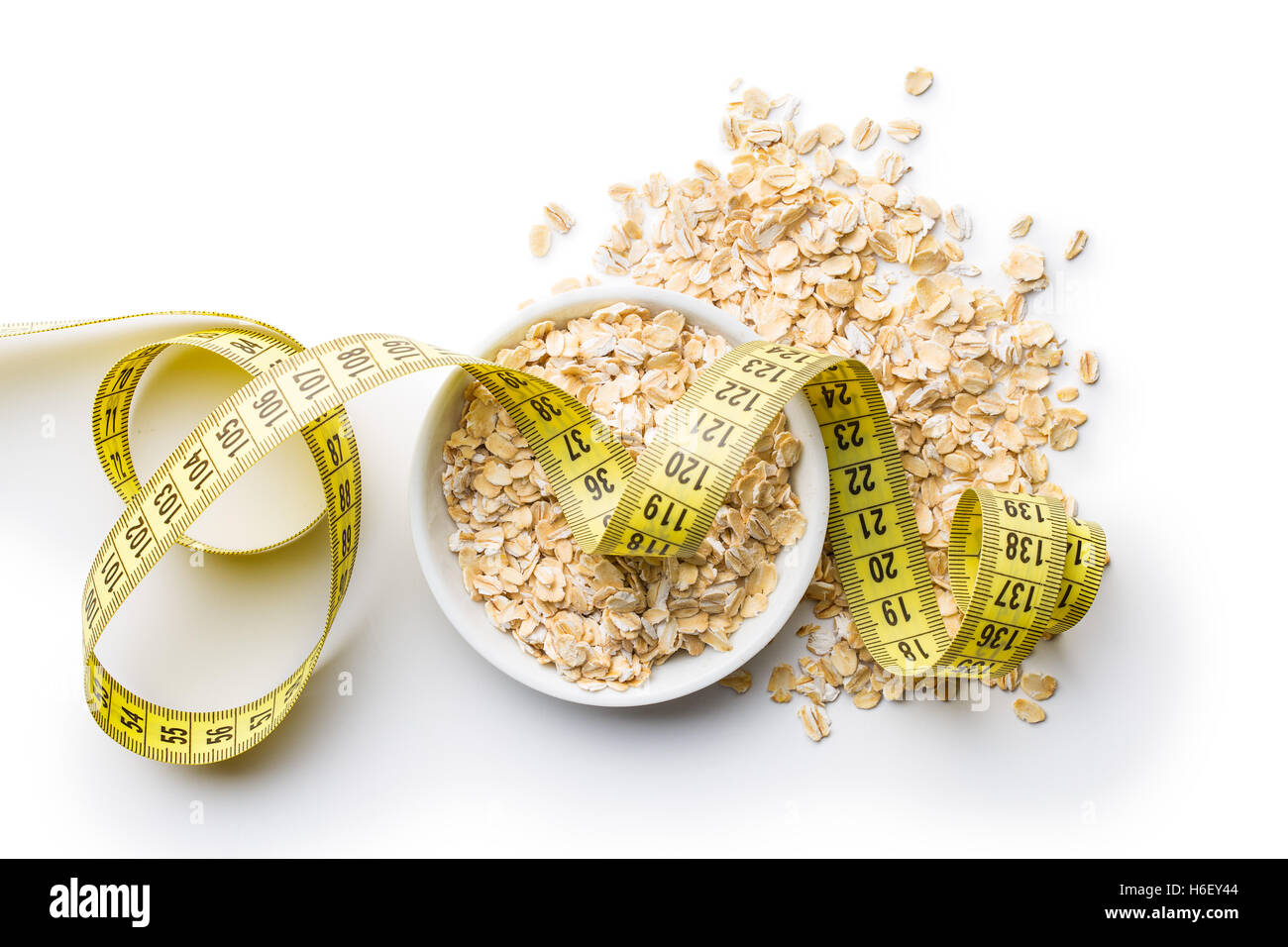 Diet concept. Oatmeal and measuring tape isolated on white background. Stock Photo