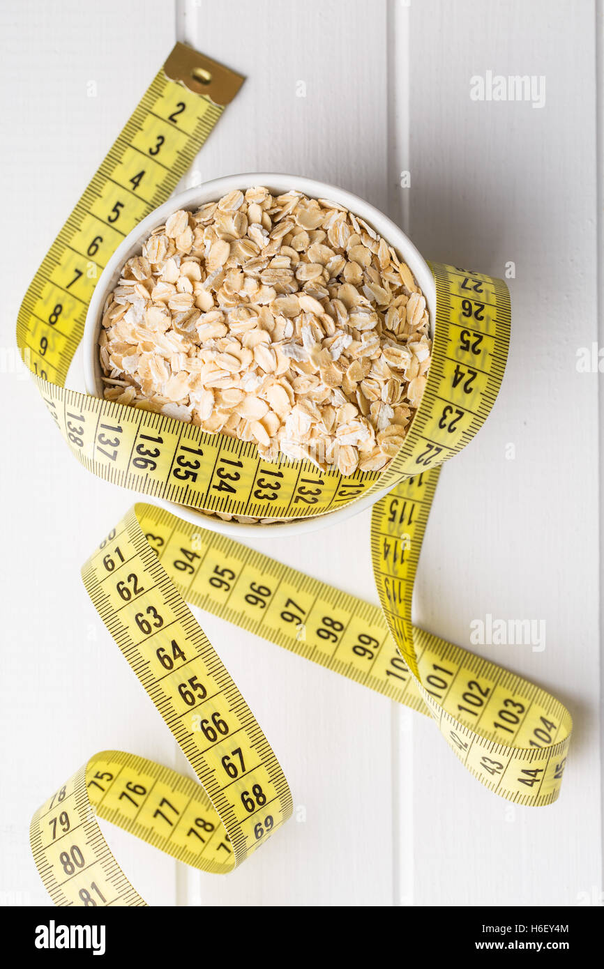 Diet concept. Oatmeal and measuring tape. Top view. Stock Photo