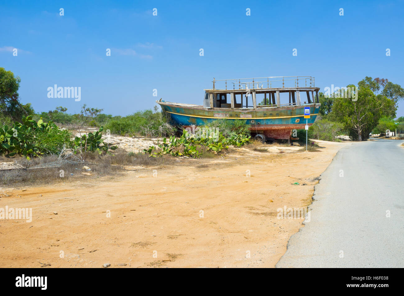 The old wooden ship is the symbol of the fishing village, so it stands next to the bus station at the village entrance, Liopetri Stock Photo