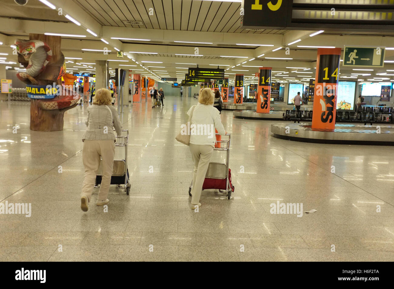Two middle-aged women at Palma Airport in Majorca in the baggage reclaim area Stock Photo