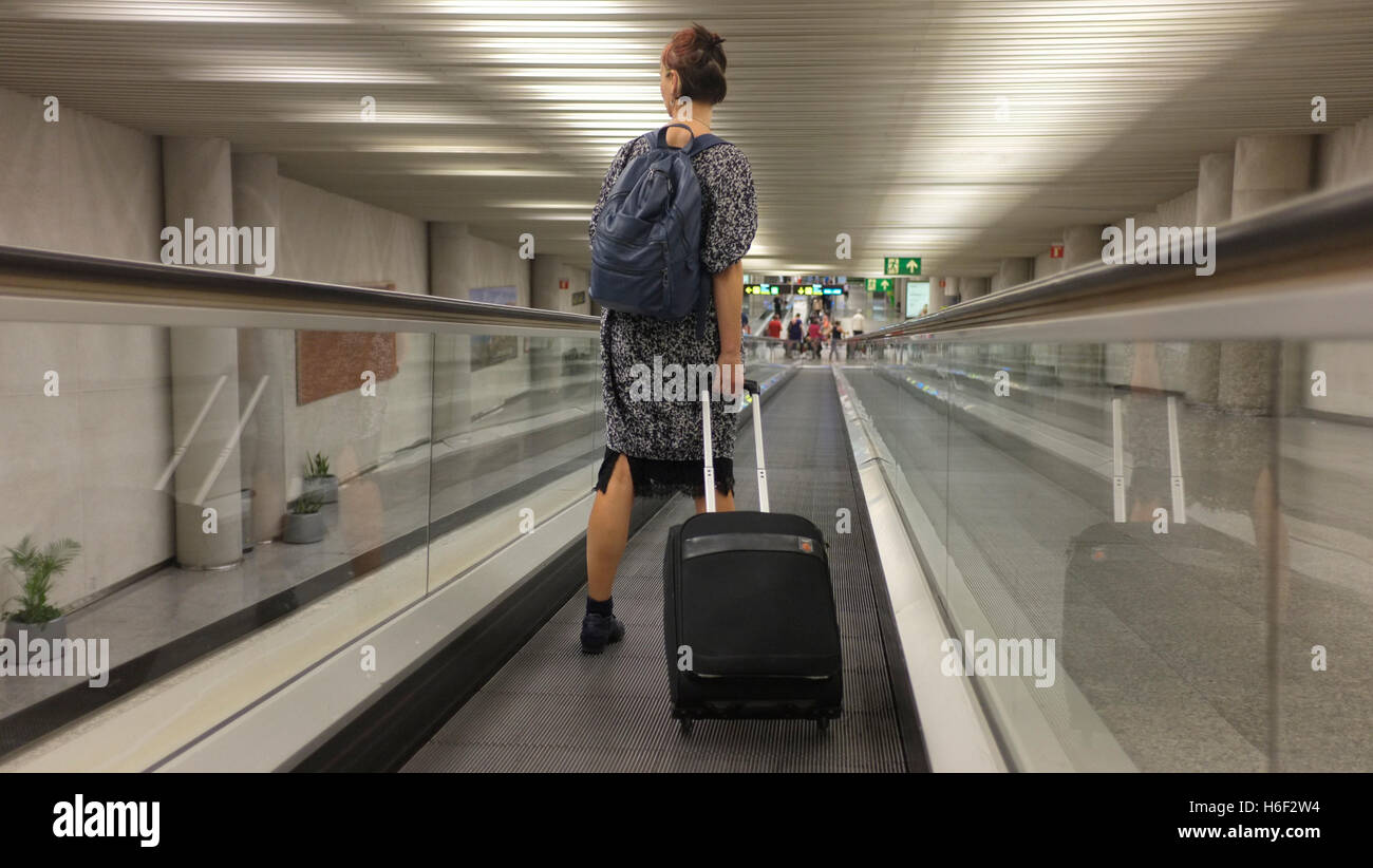 A woman on a travelator  at Palma airport in Majorca. Stock Photo