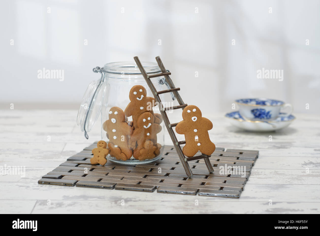 Gingerbread man climbing ladder into cookie jar Stock Photo