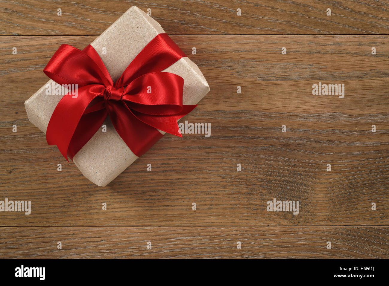 brown gift box with red ribbon bow on wooden oak table from above Stock ...