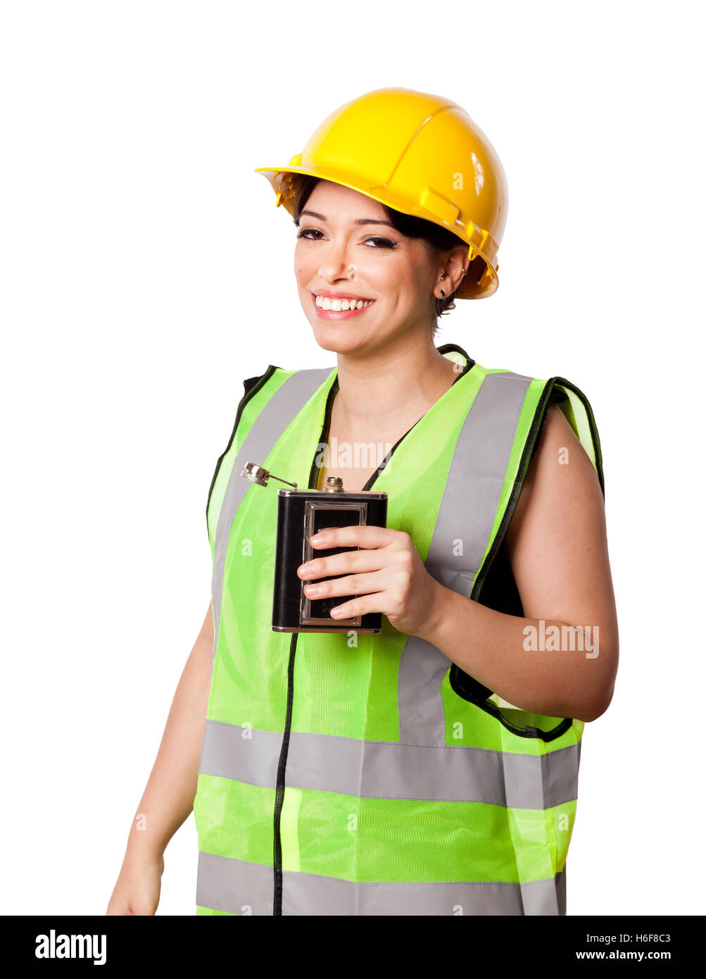 Caucasian young adult woman in her mid 20s wearing reflective yellow safety helmet and safety vest, giving the camera a drunken Stock Photo