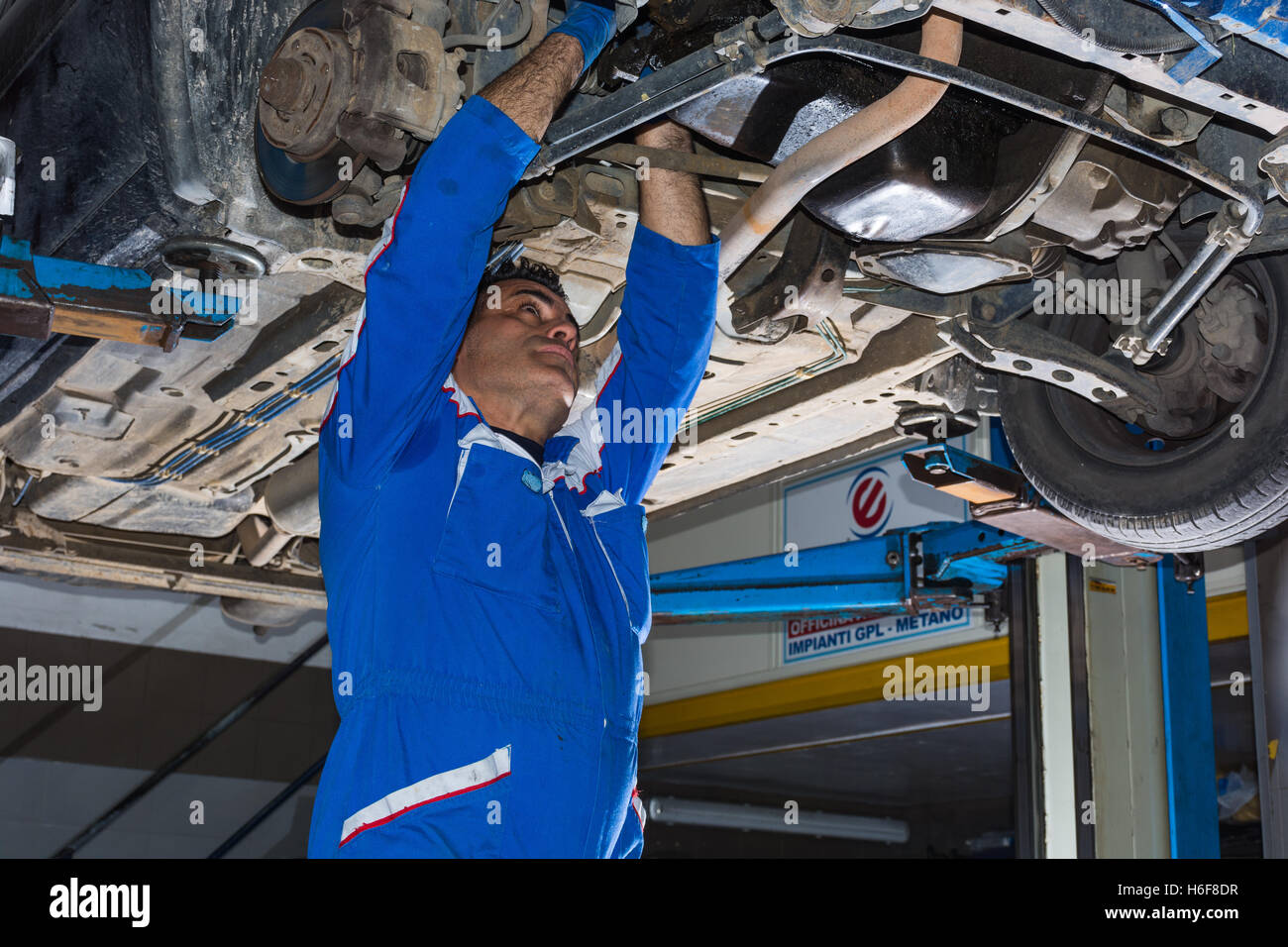 Car mechanic fixing an engine in his garage. copy space Stock Photo - Alamy
