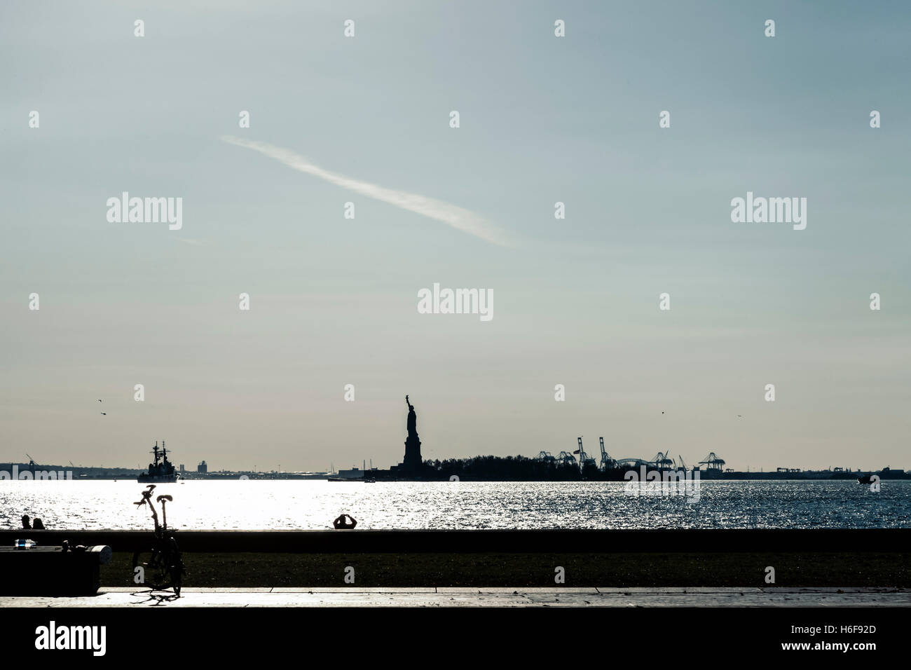 The recognizable silhouette of Statue of Liberty seen in the distance. Stock Photo