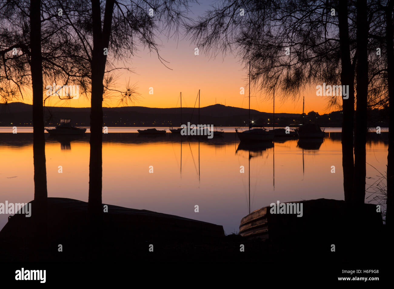 Lake Macquarie boats and Watagan Mountains at sunset NSW Australia Stock Photo