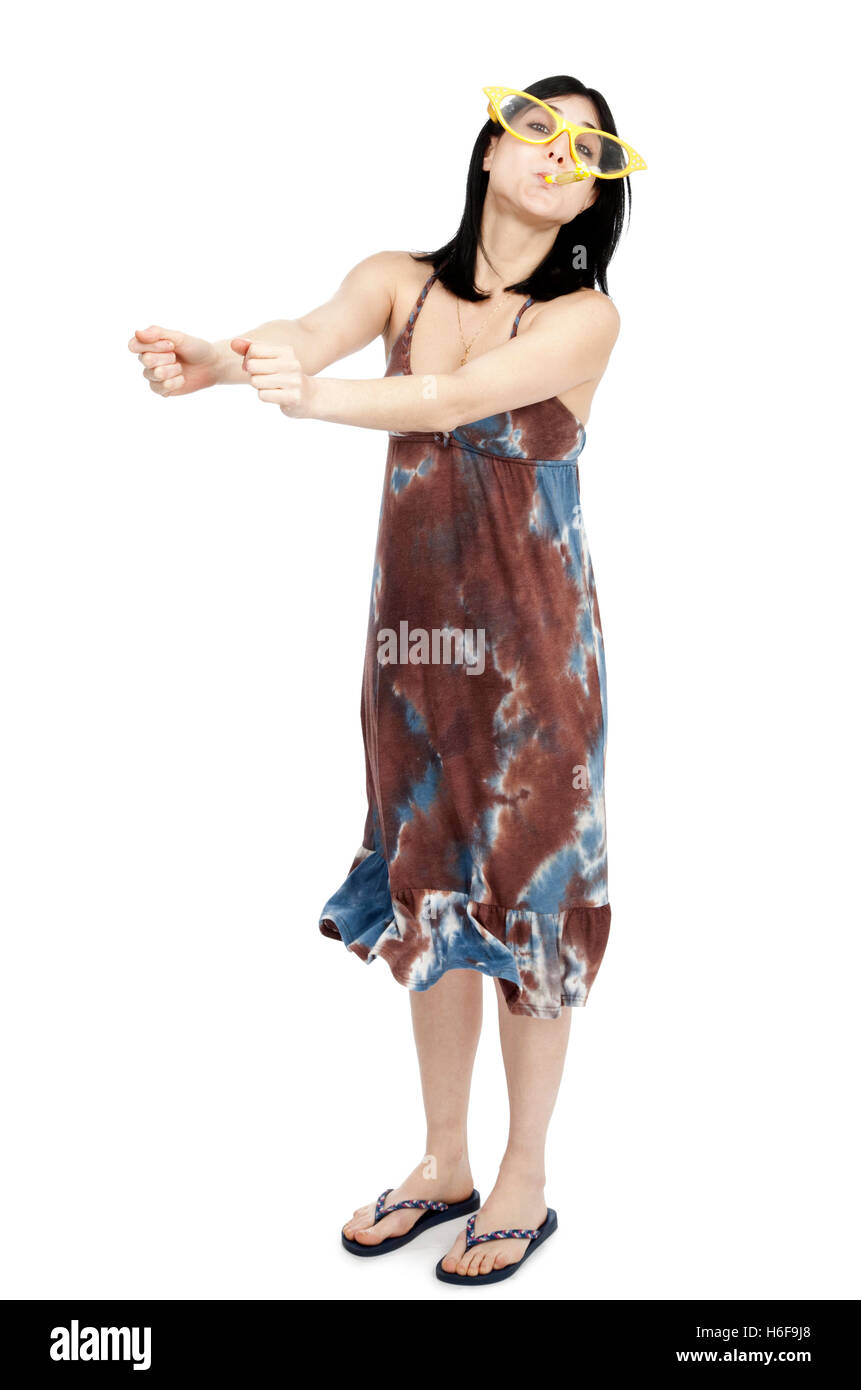 Full length view of an adult Caucasian black haired woman in her early thirties, wearing funky oversized spectacles and blowing Stock Photo