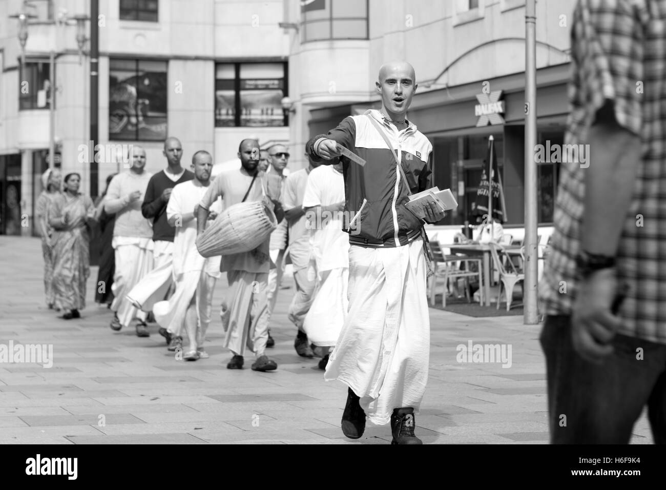 A group of Hare Krishna's chanting while walking through the streets of Cardiff handing out leaflets Stock Photo