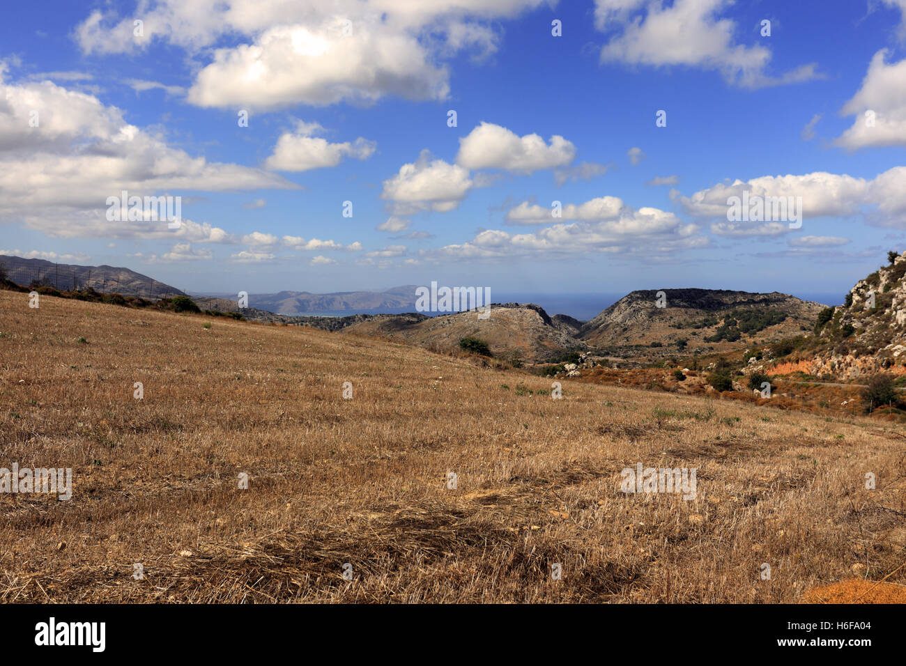 A stubble field near Moundros high in the mountains of central Crete, Greece, with spectacular views to Drapano peninsula. Stock Photo