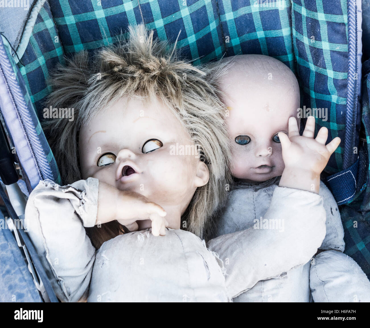 Two old dolls in pushchair in abandoned mountain house. Stock Photo