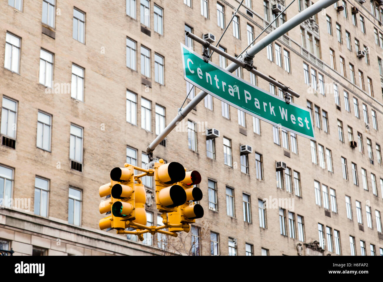 Traffic lights and green Overhead street sign depicting it is Central Park West in Manhattan, New-York, with a high rise residen Stock Photo