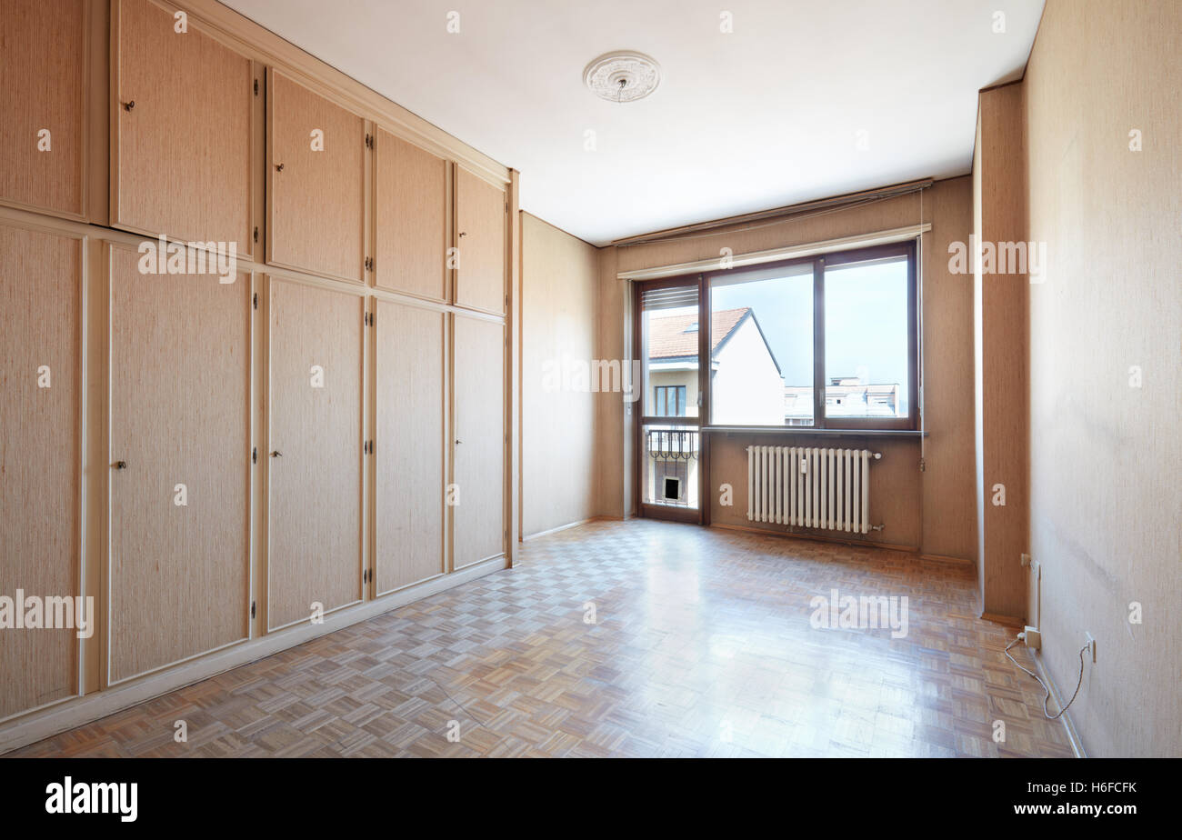 Empty old room with wooden floor and beige tapestry Stock Photo