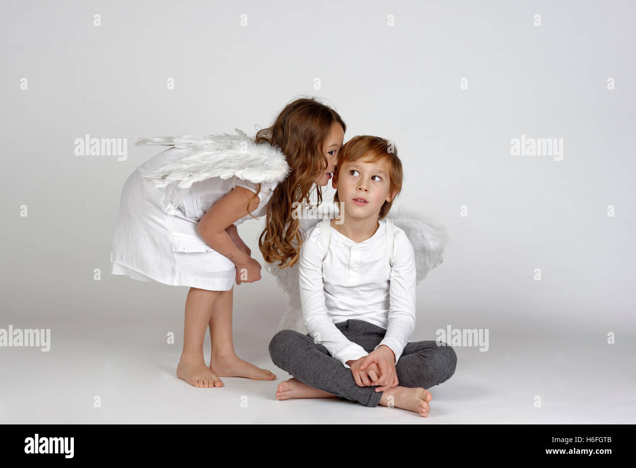 Children as Christmas angels, whispering into ear, Christmas, Upper Bavaria, Bavaria, Germany Stock Photo