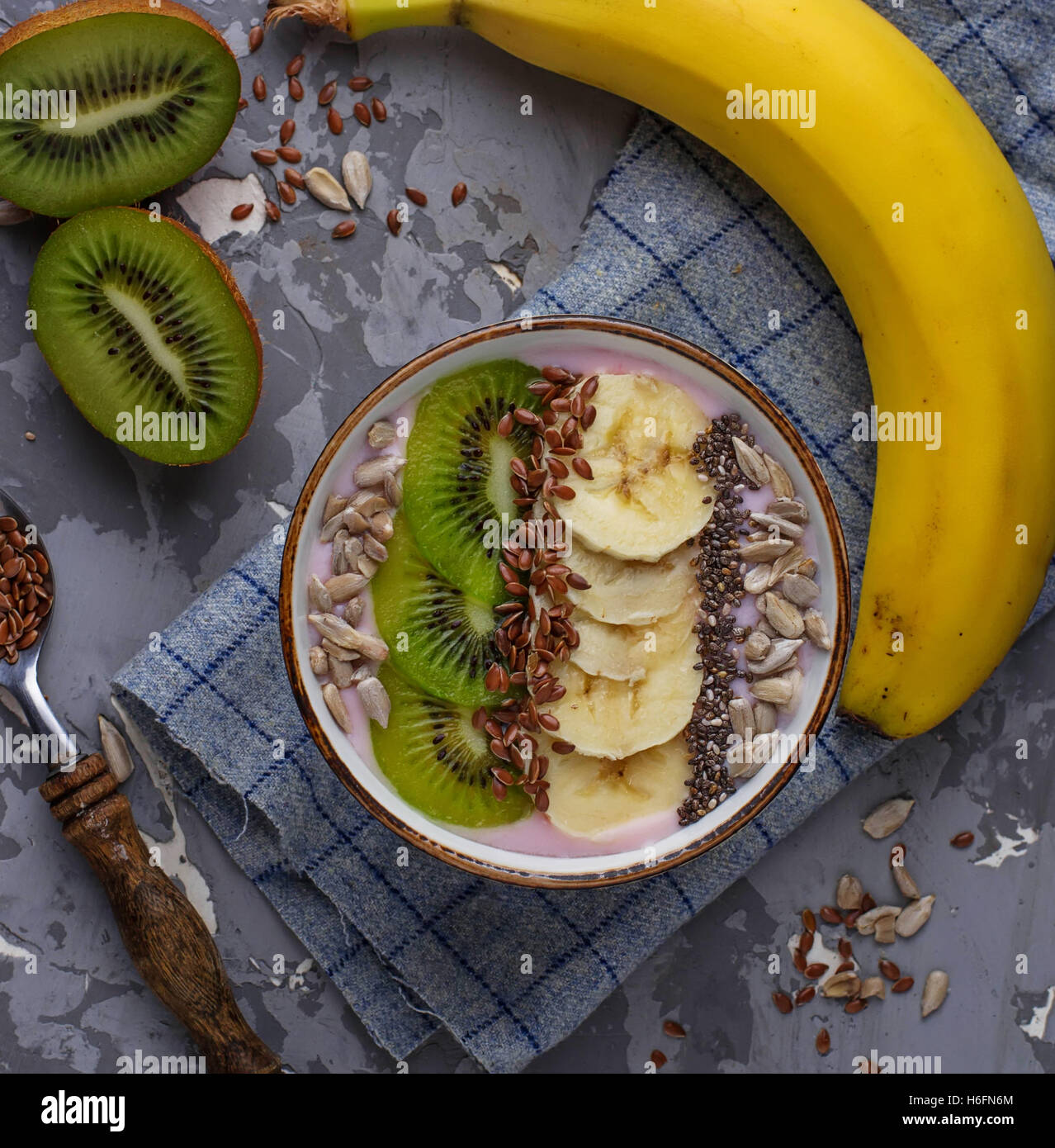 Smoothie in bowl with banana, kiwi, chia, flax and sunflower seeds