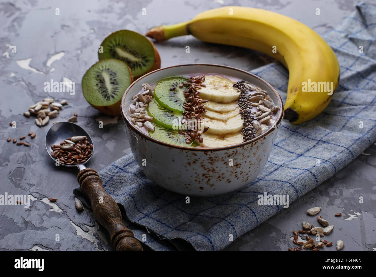 Smoothie in bowl with banana, kiwi, chia, flax and sunflower seeds