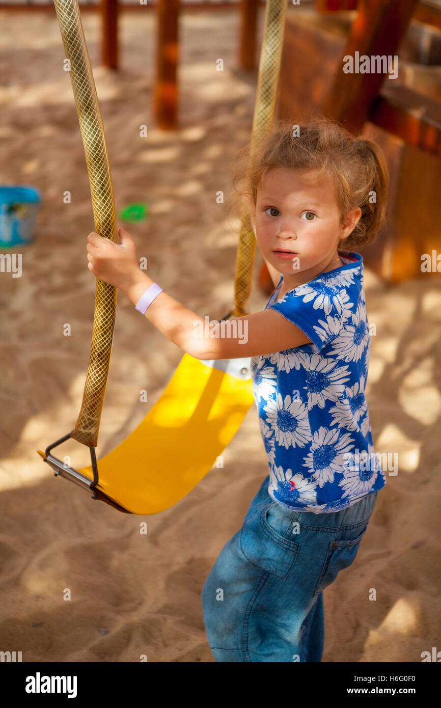 Beautiful little girl on a swing Stock Photo