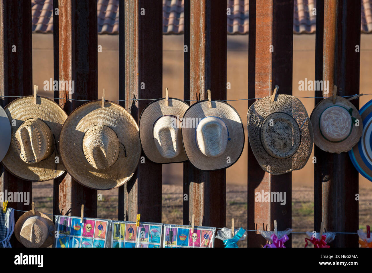 Agua Prieta, Sonora, Mexico - Hats for sale hanging on the U.S.-Mexico border fence. Stock Photo