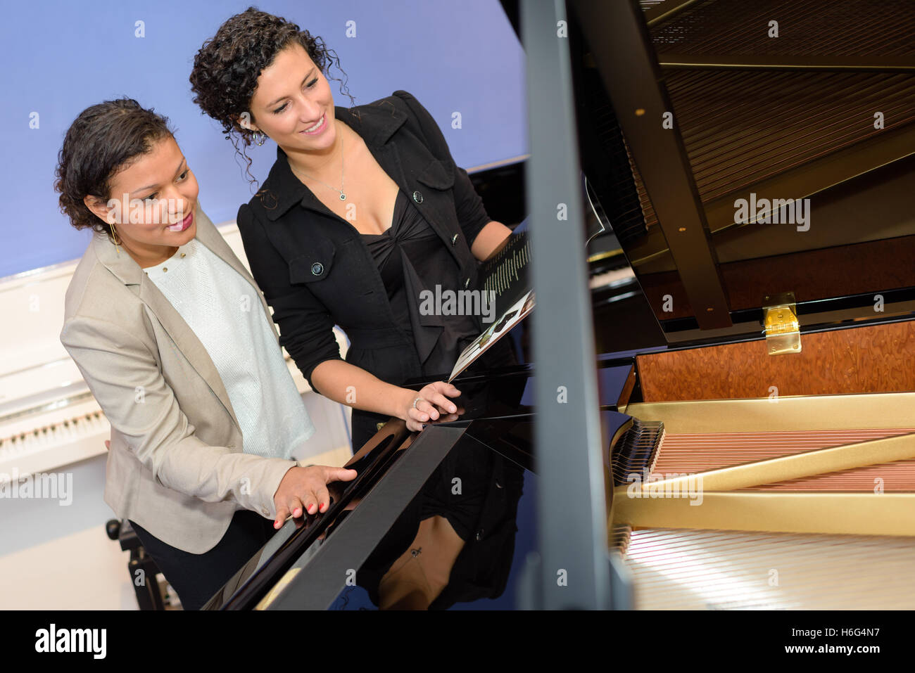 women in the piano shop Stock Photo