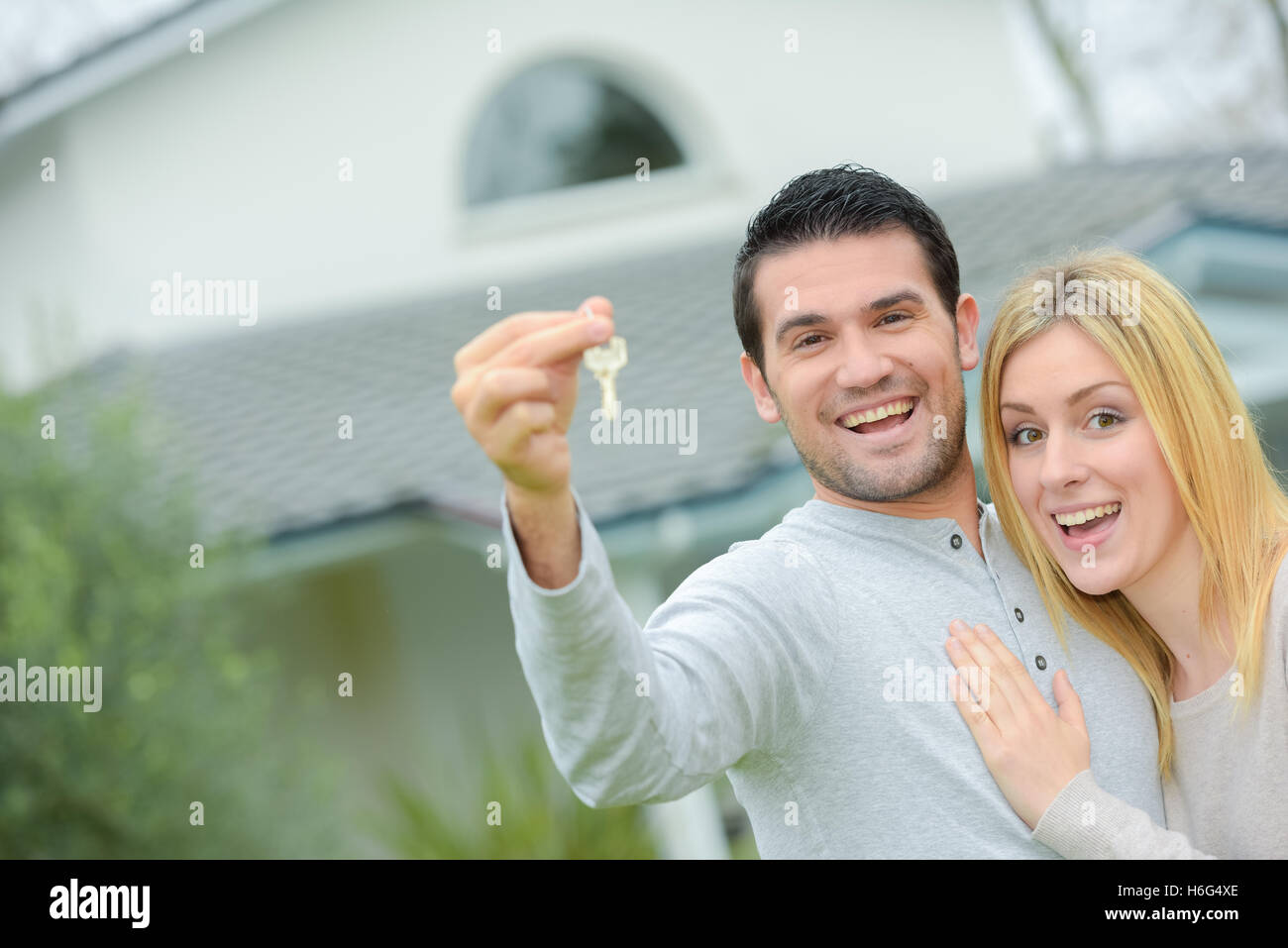 Couple holding keys to their new house Stock Photo - Alamy