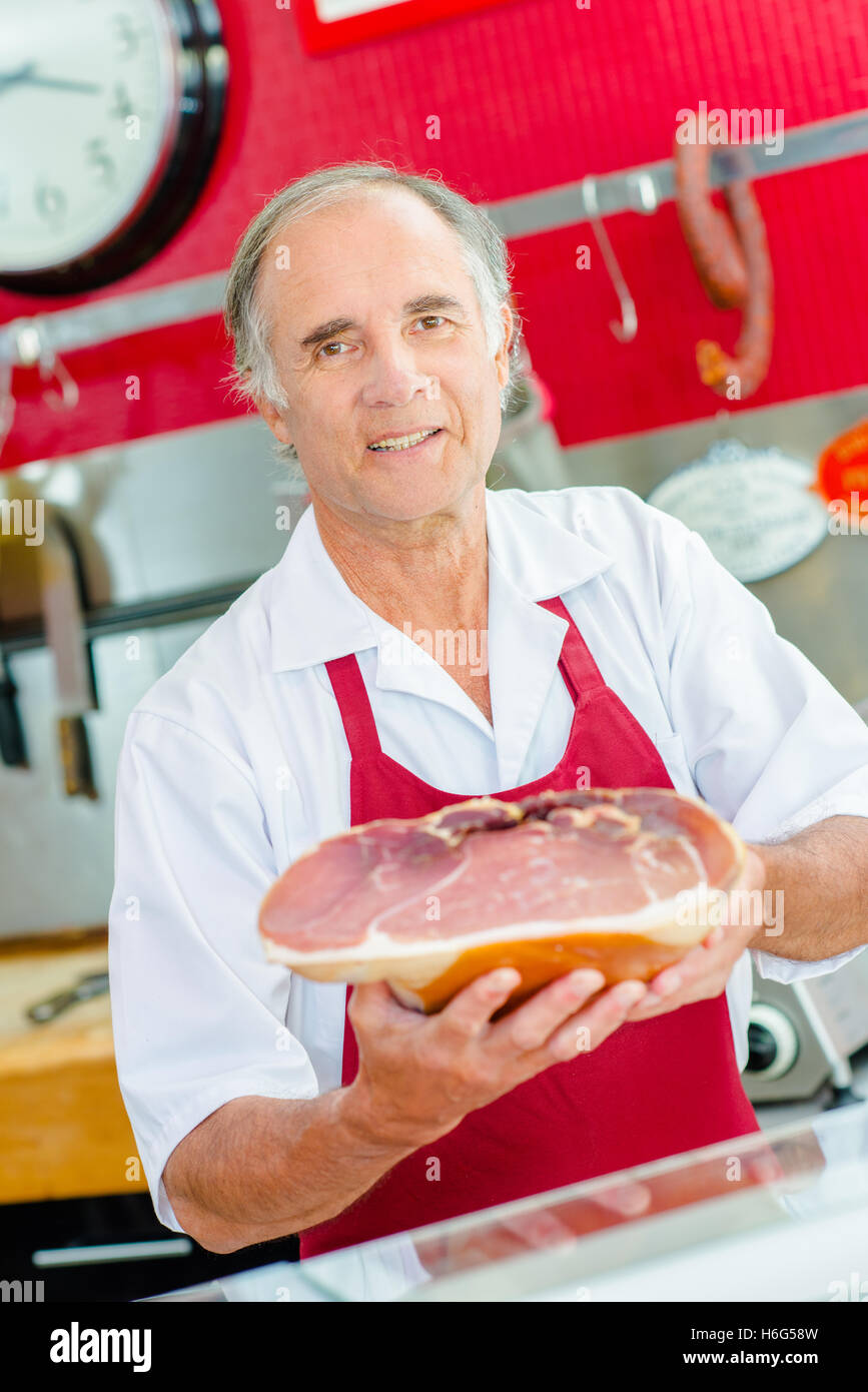 Butcher holding joint of ham Stock Photo Alamy