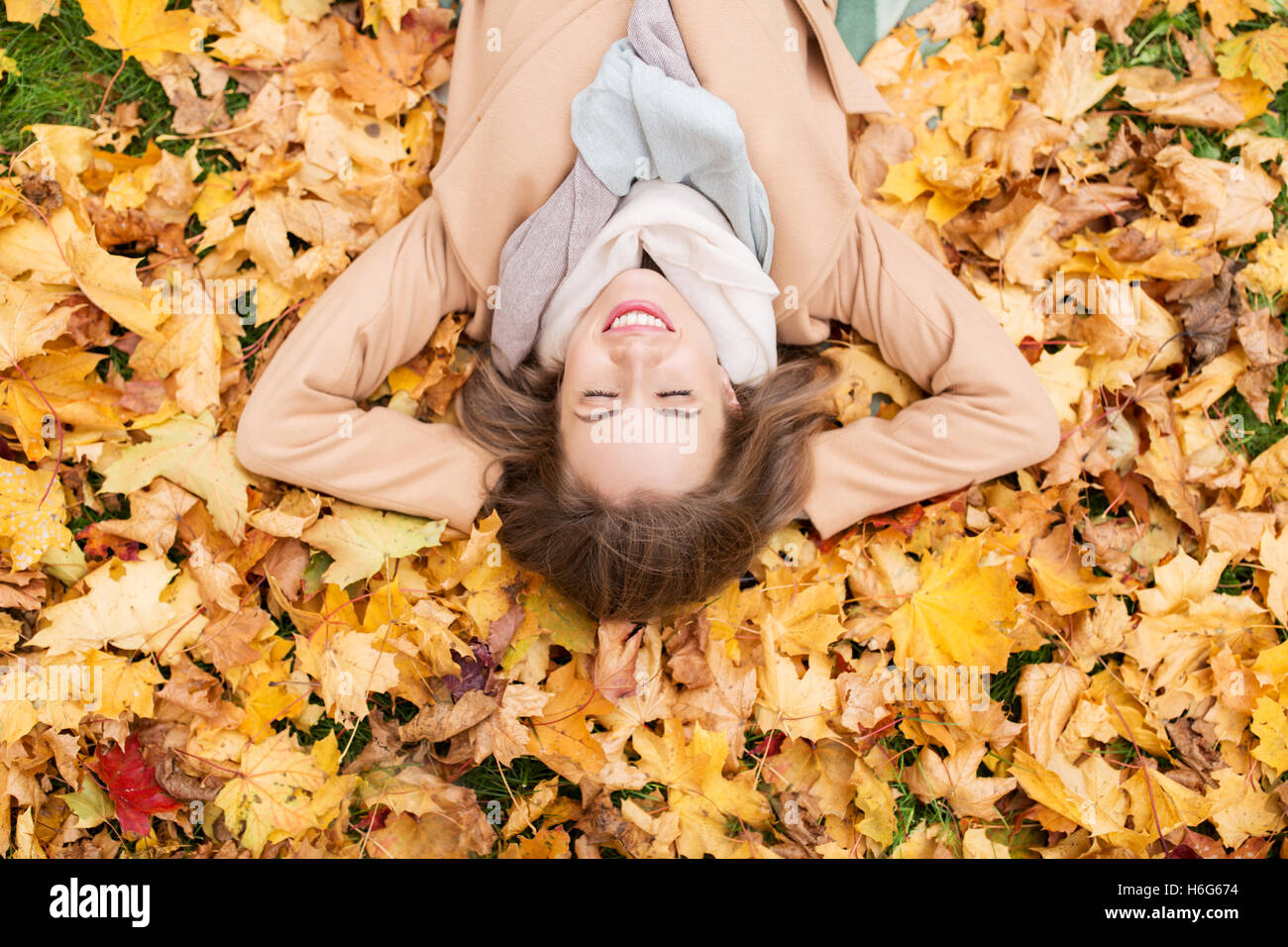 beautiful happy woman lying on autumn leaves Stock Photo - Alamy