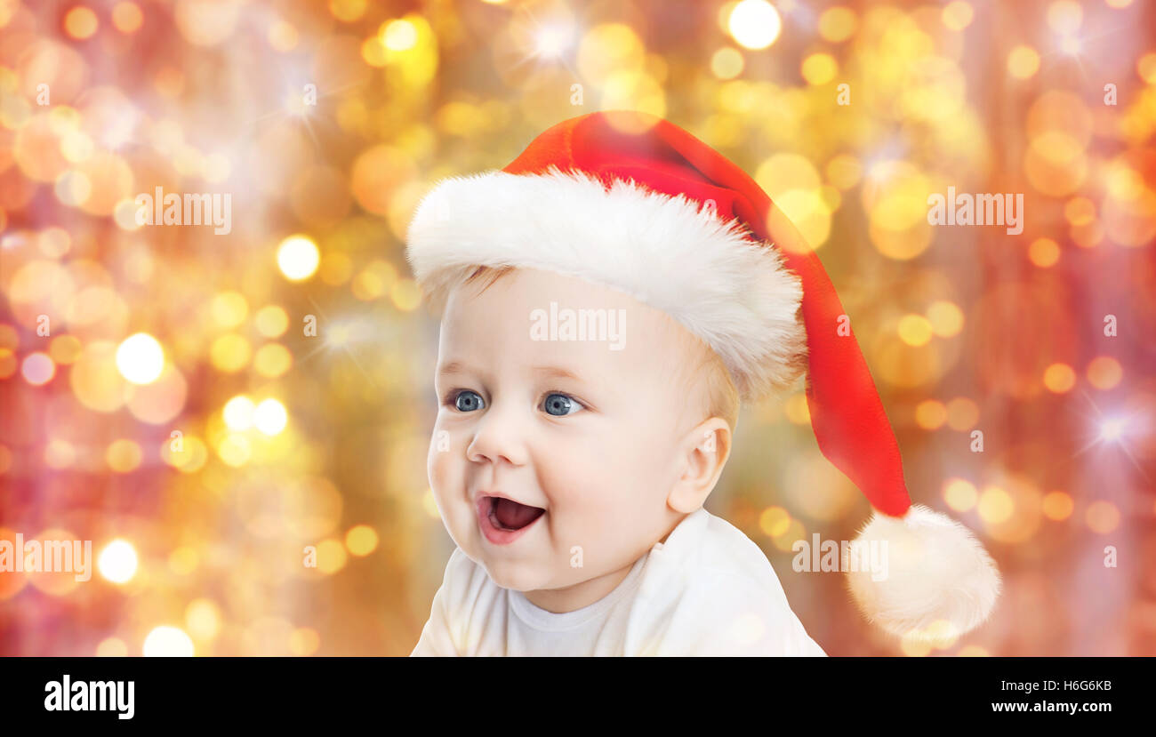 baby boy in christmas santa hat over blue lights Stock Photo